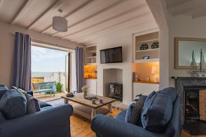 een woonkamer met 2 blauwe stoelen en een open haard bij Sea Spray Cottage by Bloom Stays in Sandgate