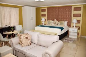 a hotel room with a bed and a couch at Clifford's Rufaro Hotel, Conference & Spa in Burgersfort +86 photos