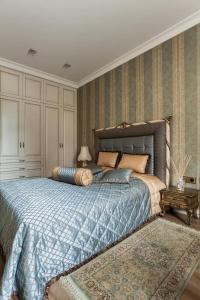 une chambre avec un grand lit avec une couverture bleue dans l'établissement Boutique Classic Apartment in Kaunas Center, à Kaunas