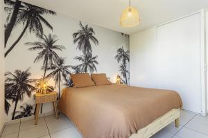 a bedroom with a bed with palm trees on the wall at T3 Universités & Hospitals - Havre de paix près Toulouse - parking - terrasse in Toulouse