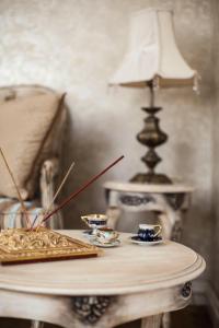 une table avec deux tasses et une lampe dessus dans l'établissement Boutique Classic Apartment in Kaunas Center, à Kaunas