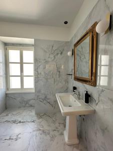 a white bathroom with a sink and a mirror at Castellano Hotel & Suites in Nafplio +37 photos