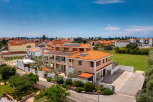 eine Luftaufnahme eines Hauses mit orangefarbenen Dächern in der Unterkunft Apartments Villa Pliško Wellness & Pool in Fažana