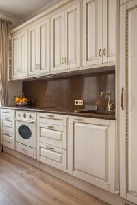 une cuisine avec des armoires blanches et un évier dans l'établissement Boutique Classic Apartment in Kaunas Center, à Kaunas