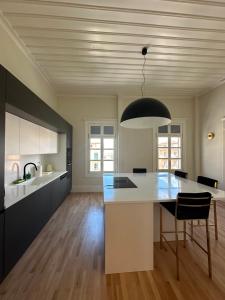 a kitchen with a table and a black pendant light at Castellano Hotel & Suites in Nafplio