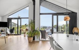un soggiorno con ampie finestre e un tavolo e sedie bianchi di 3 Bedroom Nice Home In Aabenraa a Aabenraa
