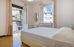 a white bedroom with a bed and a large window at Lovely Apartment In Sestri Levante in Sestri Levante