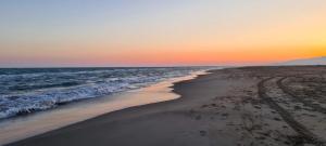 a beach with the ocean and a sunset at Lo de Joel in Els Muntells