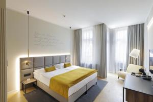 a bedroom with a king sized bed and a desk at Hotel Prokop Square in Prague
