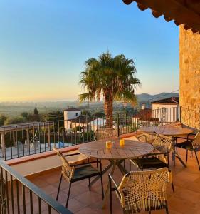 a patio with tables and chairs and a palm tree at Villa Los Primos in Calonge