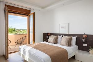 ein Schlafzimmer mit großem Bett und Balkon in der Unterkunft Apartments Villa Pliško Wellness & Pool in Fažana + 112 Fotos