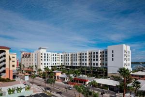 a large white building with palm trees and a street at SpringHill Suites by Marriott Clearwater Beach in Clearwater Beach