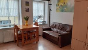 a living room with a leather couch and a table at 1-Zimmer-Apartment-1-im-1-Obergeschoss in Lübeck