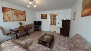 a living room with a couch and a table at 2-Zimmer-Ferienwohnung-im-1-Obergeschoss in Lübeck
