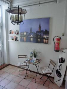 a table and chairs in a room with a picture on the wall at 2-Zimmer-Ferienwohnung-im-1-Obergeschoss in Lübeck