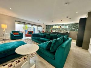 a living room with a green couch and a table at Beachy House St Andrews in St. Andrews