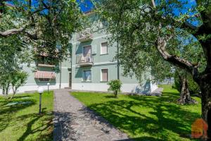 Un edificio verde con un banco en un parque. en - Lake Bliss, en Desenzano del Garda