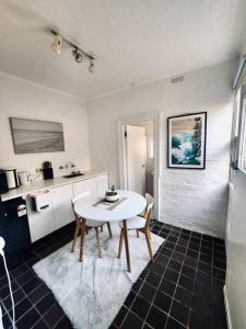 a kitchen with a table and chairs in a room at Rear Garden Suite in Sydney