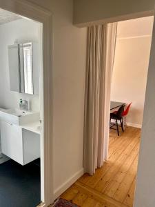 a bathroom with a sink and a mirror and a table at Ole Rømers Gade 108 in Aarhus