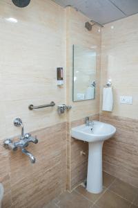 a bathroom with a sink and a mirror at Ishwerya Suites in Bengaluru