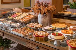a buffet with many different types of cakes and pies at Praia Hotel Imbituba in Imbituba