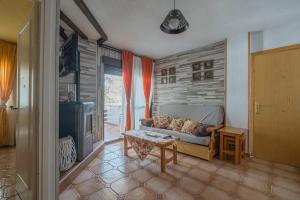 una sala de estar con un sofá y una mesa en Apt Romántico con chimenea con Fibra óptica y terraza, en San Martín de Valdeiglesias