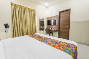 a hotel room with a bed and a desk at FabHotel MRV Inn in Chennai