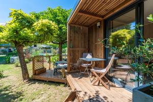 a house with a wooden deck with a table and chairs at Chambre d'hôtes de la dame blanche in Borrèze