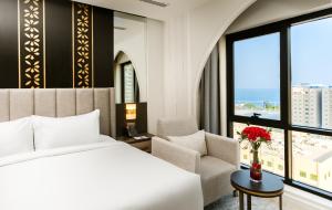 a hotel room with a bed and a chair and a window at The Address Serviced Apartments in Al Khobar +139 photos