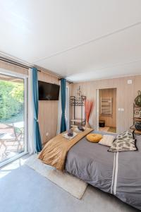 a bedroom with a large bed and a large window at Chambre d'hôtes de la dame blanche in Borrèze