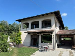 a large white house with a patio in the yard at Rinirma in Cocconato