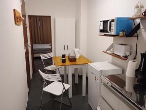 a small kitchen with a table and chairs and a microwave at Mercedes Aparts in Mercedes