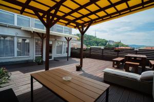 a wooden deck with a table and benches on a building at Panoráma Apartman in Miskolc