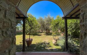 an arched doorway to a garden with trees at Pet Friendly Home In Cetona in Cetona