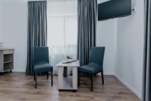 a room with two chairs and a table and a window at Aparthotel Plevnei2 in Cluj-Napoca
