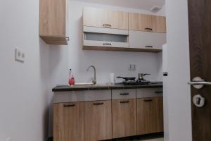 a kitchen with wooden cabinets and a sink at Aparthotel Plevnei2 in Cluj-Napoca +5 photos