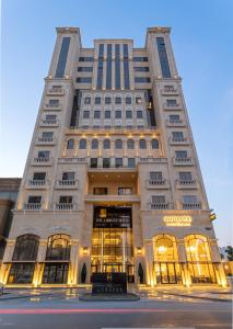 a tall white building with a store front at The Address Serviced Apartments in Al Khobar