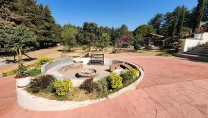 a park with a bench and a fire pit at La Villafranca del Cid in Zitácuaro