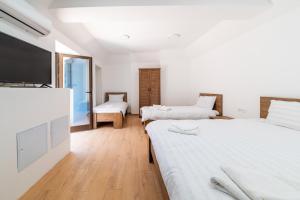 a bedroom with two beds and a flat screen tv at Colours Plus in Sarajevo