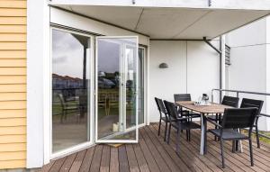 a patio with a table and chairs on a deck at Gudhjem Søpark Lejl 1 in Gudhjem +14 photos