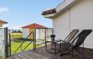 a pair of chairs and a table on a deck at Gudhjem Søpark Lejl 28 in Gudhjem
