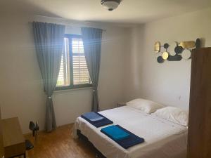 Un dormitorio con una cama blanca con una ventana. en Apartma Bossamarino, en Koper