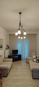 a living room with two couches and a television at Efchi city center apartment in Katerini