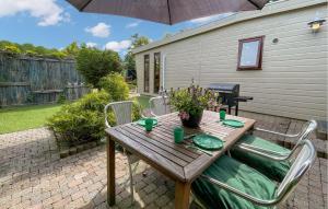 a wooden table with chairs and an umbrella on a patio at Awesome Stacaravan In Tzummarum in Tzummarum