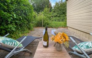 a bottle of wine sitting on a table with two chairs at Awesome Stacaravan In Tzummarum in Tzummarum +13 photos