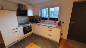 a small kitchen with white cabinets and a window at Apart Studio 71 in Altenmarkt im Pongau