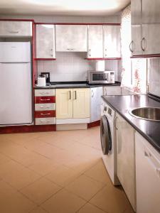 a large kitchen with white cabinets and a sink at Villa Teresa in La Bañeza