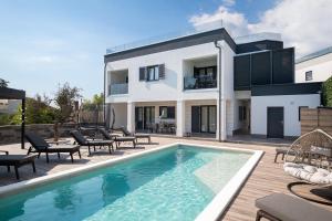 ein Haus mit einem Swimmingpool davor in der Unterkunft Villa Blue Banjole in Banjole