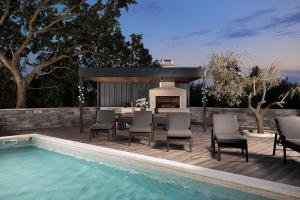 eine Terrasse mit Tisch und Stühlen neben einem Swimmingpool in der Unterkunft Villa Blue Banjole in Banjole