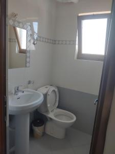 a white bathroom with a toilet and a sink at Villa Zeka Ksamil in Ksamil